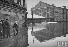 Семья смотрит на залитые водой улицы города
